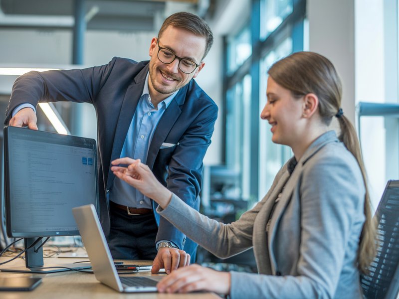 IT-Experte von 030-IT berät eine Mitarbeiterin am Computerarbeitsplatz im Büro – Business Computerservice für Unternehmen in Berlin und Potsdam